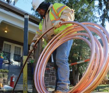 Photo of a worker installing copper pipe
