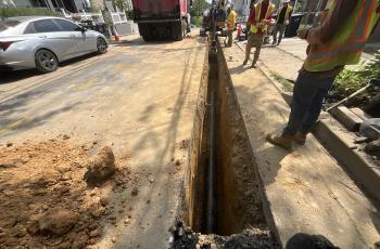 Workers laying replacement pipe.